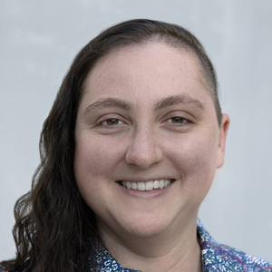 Rachel Leiken, a white woman with an undercut, wearing a floral shirt and against a white background
