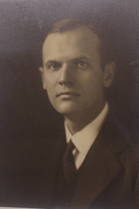 A black and white portrait photo of Elmore McKee, a white man with short hair wearing a suit.