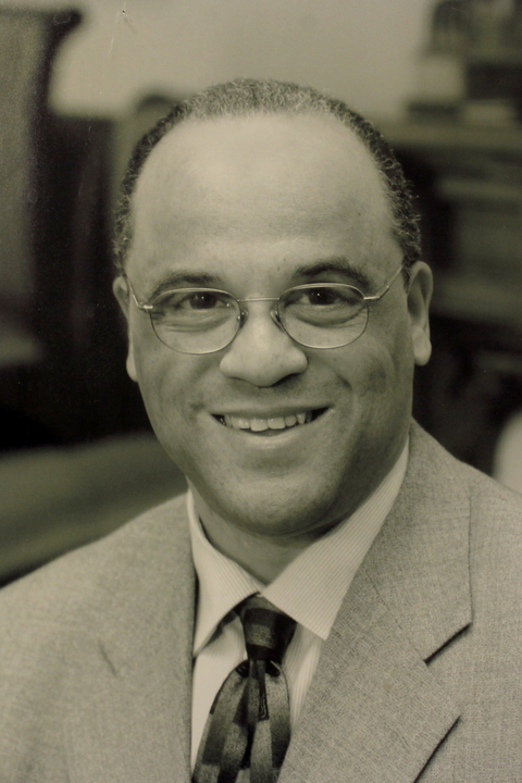 Black and white photo of Frederick Streets, a Black man with short cropped hair wearing a suit and glasses.