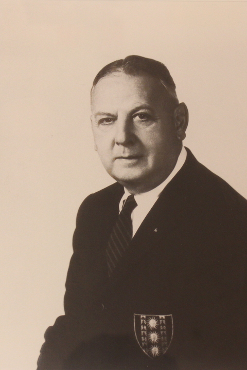 A black and white posed portrait photo of Sidney Lovett, a white man with short hair in a suit.