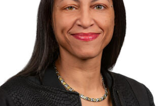 Rende Wilson, a light skinned black woman with long straight black hair, smiling at the camera