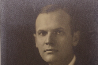 A black and white portrait photo of Elmore McKee, a white man with short hair wearing a suit.