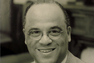 Black and white photo of Frederick Streets, a Black man with short cropped hair wearing a suit and glasses.