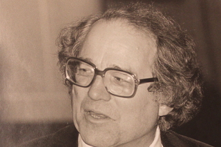 Black and white photo of William Sloane Coffin Jr., a white man with medium length slicked back hair and thick glasses