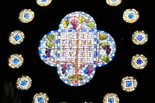 A closeup of the rose window, displaying the Yale coat of arms in stained glass.