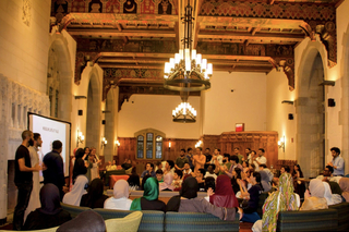 Photo of a large room on Yale's campus with a crowded meeting of the Muslim Student Association.